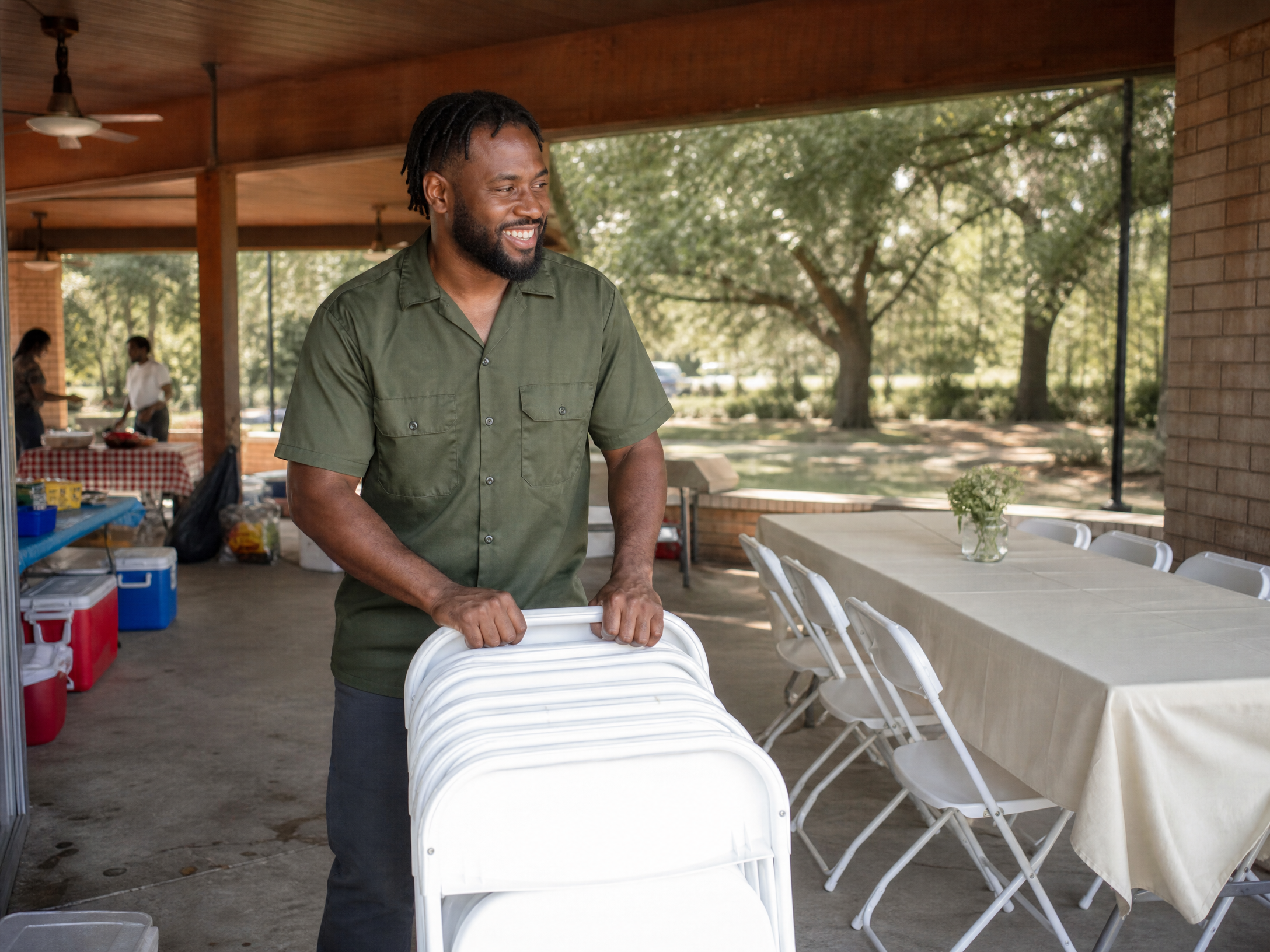 A friendly team member setting up chairs at a neighborhood pavilion